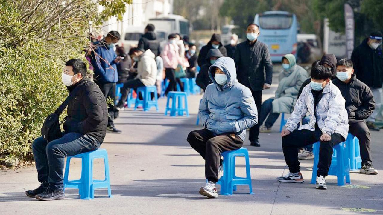 ચીનના જિઆંગસુ પ્રાંતમાં નાનજિંગમાં એક ક્લિનિકની બહાર સારવાર માટે કતારમાં બેસી રહેલા લોકો.