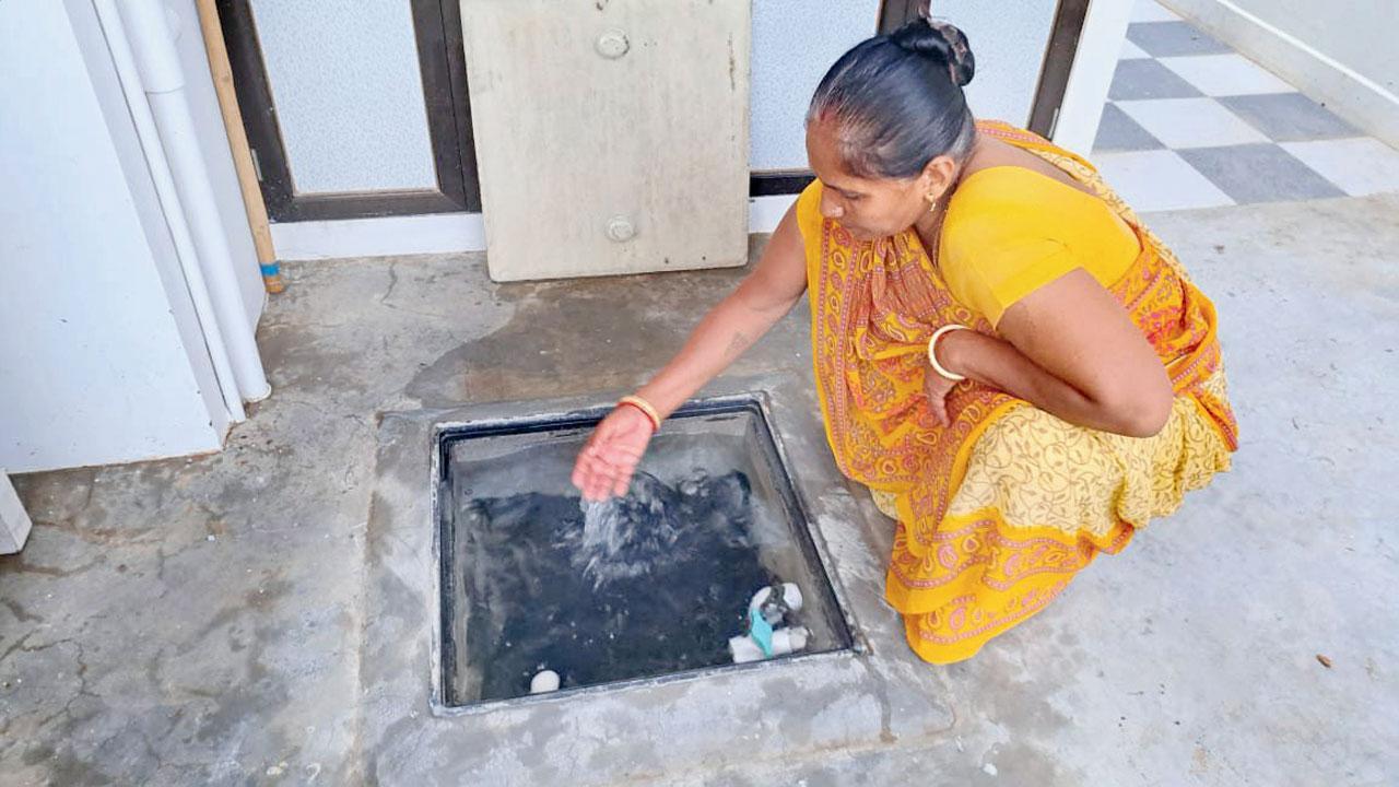 સુખપર ગામમાં ઘરમાં રહેલા વરસાદના પાણીના ભૂગર્ભ ટાંકામાં ભરાયેલા પાણીને તપાસી રહેલાં દેવુબહેન વેલાણી.