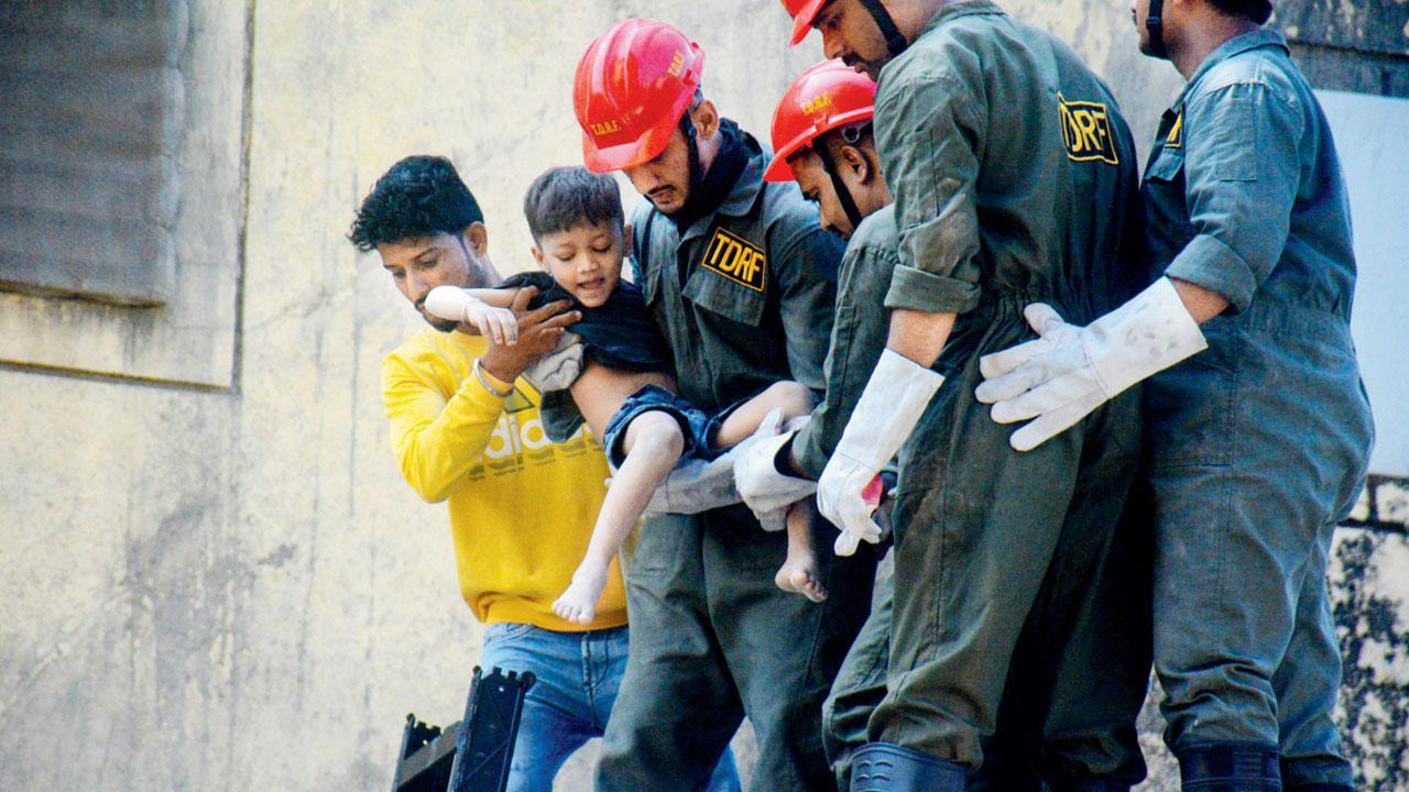 ભિવંડીમાં તૂટી પડેલું ગોડાઉન અને કાટમાળની નીચેથી બચાવી લેવામાં આવેલું બાળક.  પી.ટી.આઈ.