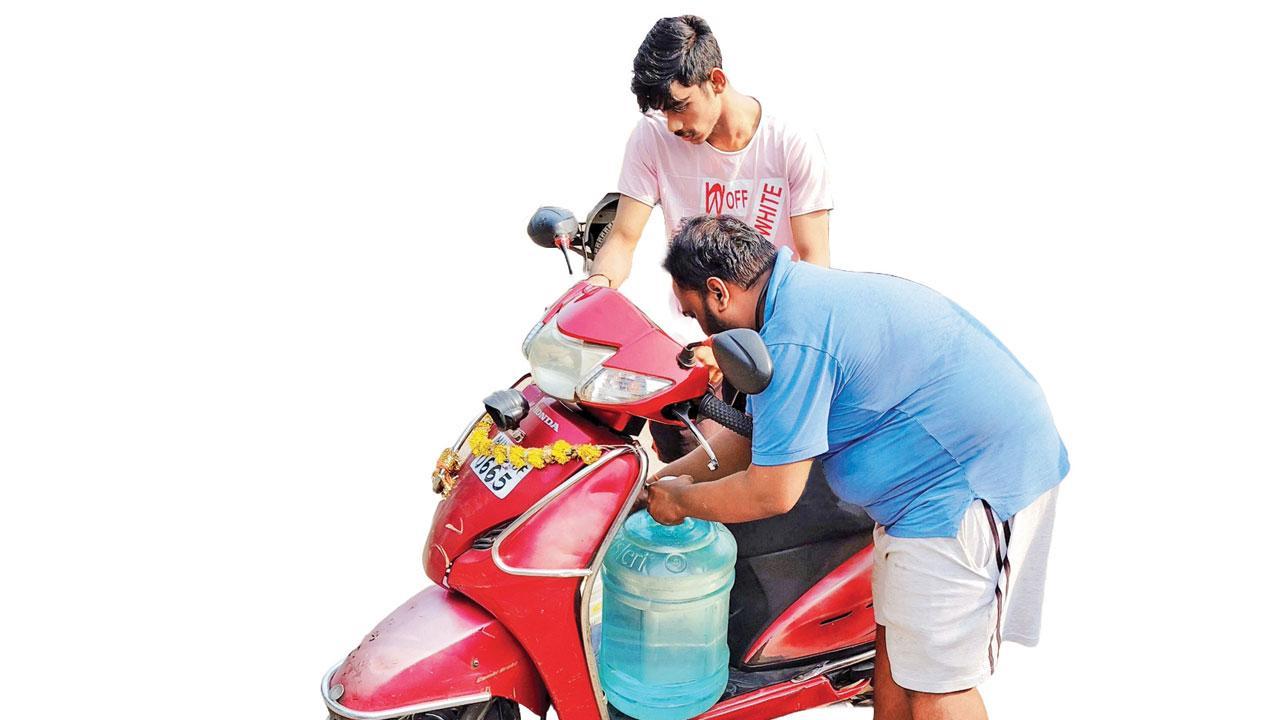 પાણીની અછતને લીધે ભરતડકામાં તેમનાં સગાંને ત્યાંથી સ્કૂટર પર પીવાનું પાણી ભરીને લઈ જઈ રહેલા યુવાનો