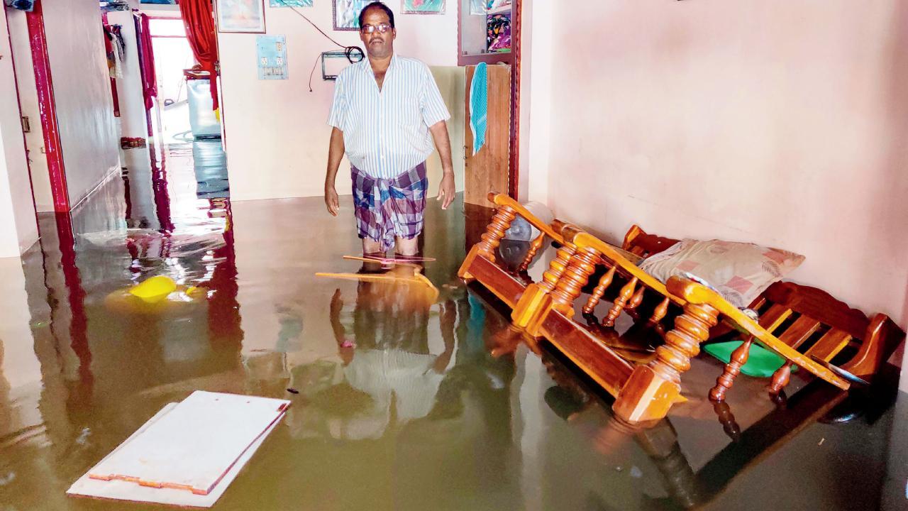 ચેન્નઈમાં ગઈ કાલે મિચૌન્ગ ચક્રવાતી તોફાનને કારણે ભારે વરસાદમાં પોતાના ઘરમાં પાણી ઘૂસી જવાને કારણે વિવશ વ્યક્તિ.
