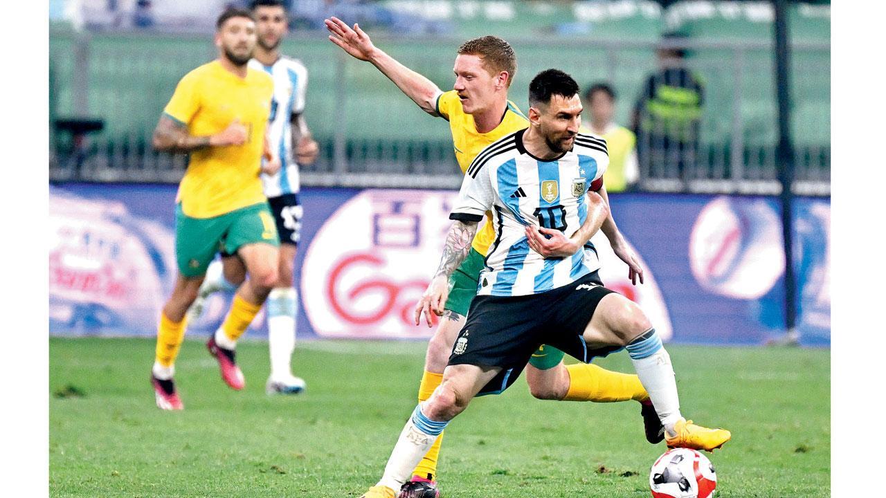 ગુરુવારે બીજિંગની મૅચમાં મેસીને બૉલ પર કબજો કરીને ગોલ કરતો રોકી રહેલો ઑસ્ટ્રેલિયન પ્લેયર.  એ.એફ.પી.