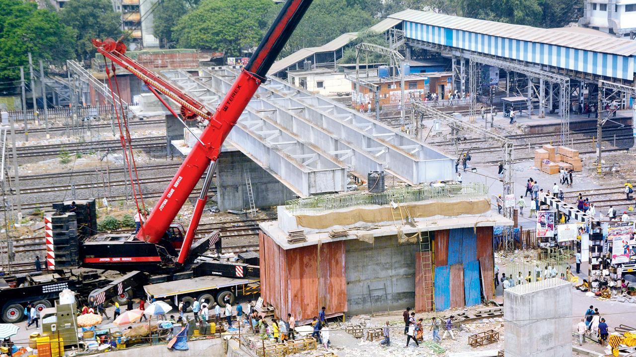 વર્કરોએ દિવા સ્ટેશન પાસે આવેલા લેવલ ક્રૉસિંગ પર બની રહેલા ઓવરબ્રિજ પર બે ગર્ડર બેસાડ્યા (તસવીર : સતેજ શિંદે)