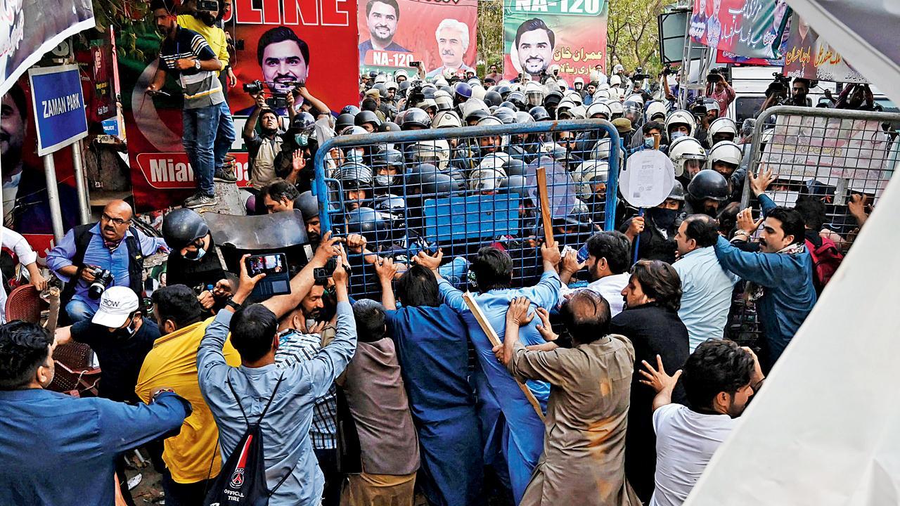 લાહોરમાં ગઈ કાલે ઇમરાન ખાનની ધરપકડ કરતી પોલીસને રોકવાની કોશિશ કરી રહેલા ઇમરાનના સમર્થકો. 