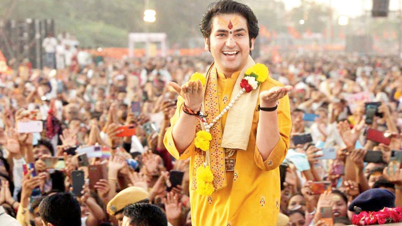 સુરતમાં શુક્રવારે યોજાયેલા દરબારમાં પોતાની આગવી સ્ટાઇલમાં ભાવિકોનું અભિવાદન કરી રહેલા ધીરેન્દ્ર શાસ્ત્રી