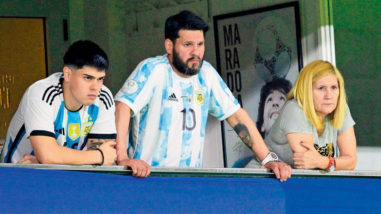 ગુરુવારે બ્યુનસ આયરસમાં લિયોનેલ મેસીની મૅચ તેની મમ્મી સેલિયા મારિયા (જમણે) તેમ જ તેના ભાઈ માટિયાસે (વચ્ચે) જોઈ હતી. એક તબક્કે મેસી ફ્રી કિકને ગોલમાં ફેરવવામાં નિષ્ફળ જતાં નિરાશ થઈ ગયો હતો.  એ.એફ.પી.