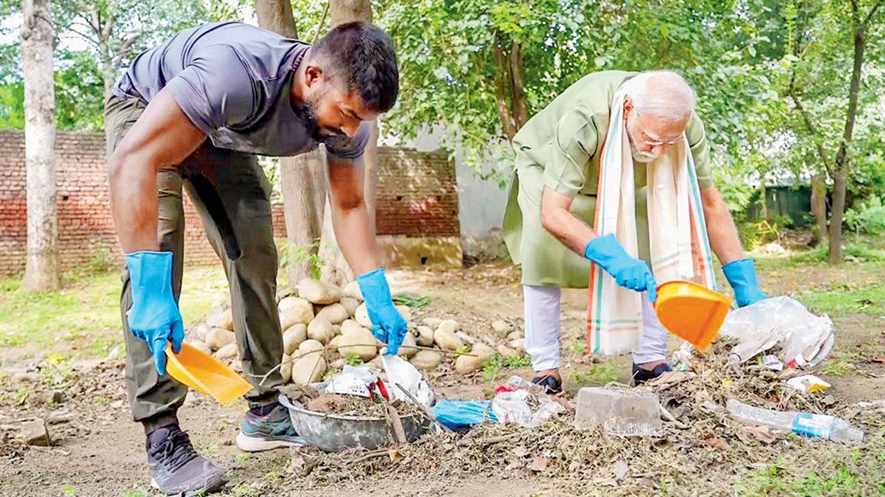 નવી દિલ્હીમાં ગઈ કાલે ‘સ્વચ્છતા હી સેવા’ કૅમ્પેનના ભાગરૂપે ‘સ્વચ્છતા માટે શ્રમદાન’ કાર્યક્રમમાં ભાગ લઈ રહેલા ફિટનેસ ઇન્ફ્લુઅન્સર અંકિત બૈયનપુરિયાની સાથે પીએમ નરેન્દ્ર મોદી (તસવીર : એ.એન.આઇ.)