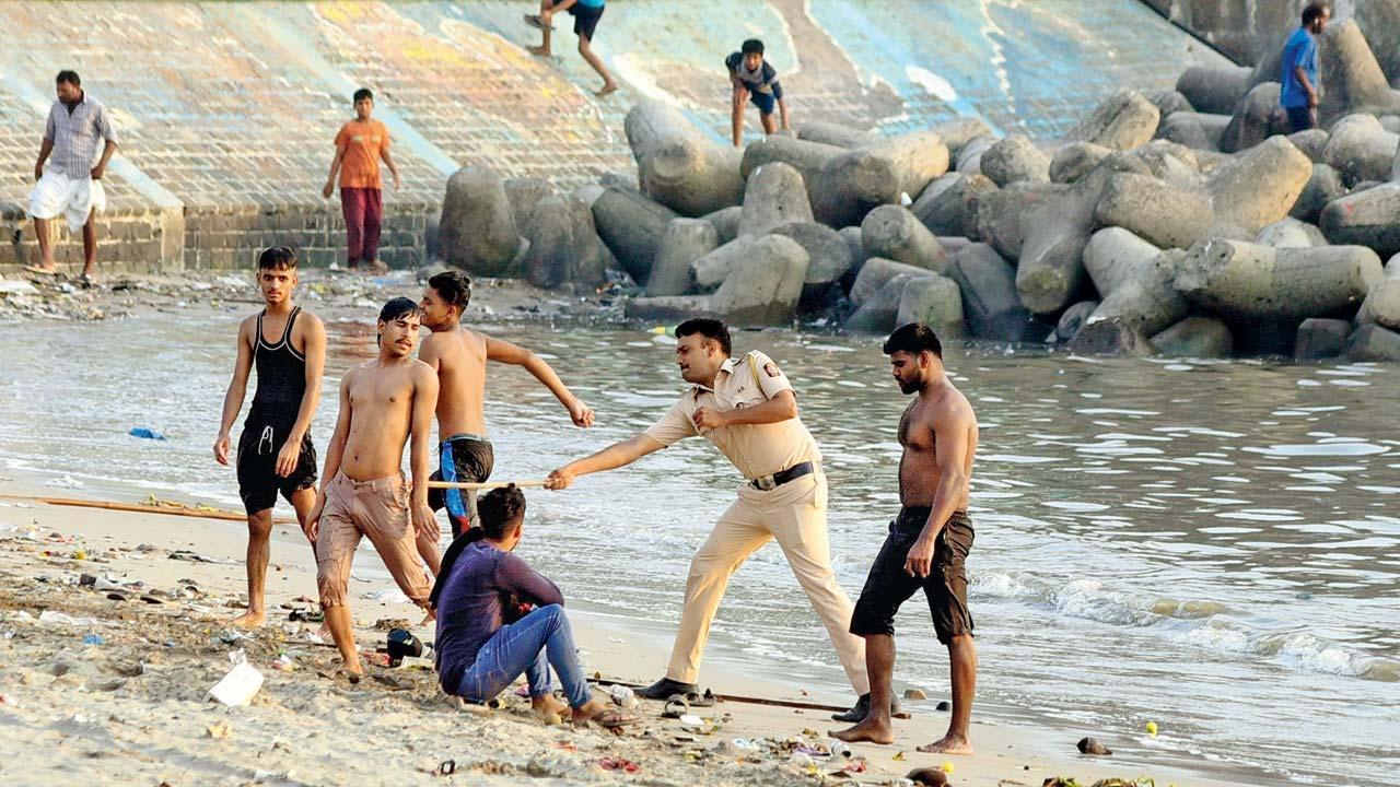 આકરી ગરમીથી બચવા માહિમ બીચ પર દરિયામાં નાહવા પડેલા કેટલાક છોકરાઓને ગઈ કાલે પોલીસે લાઠી ફટકારીને તગેડ્યા હતા.  (શાદાબ ખાન)