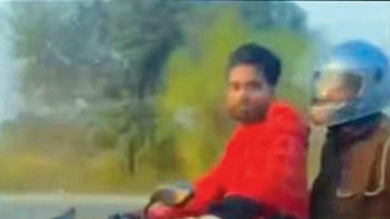 એક ક્રિમિનલને હાથકડી પહેરાવાઈ છે અને તે બાઇક ચલાવી રહ્યો છે