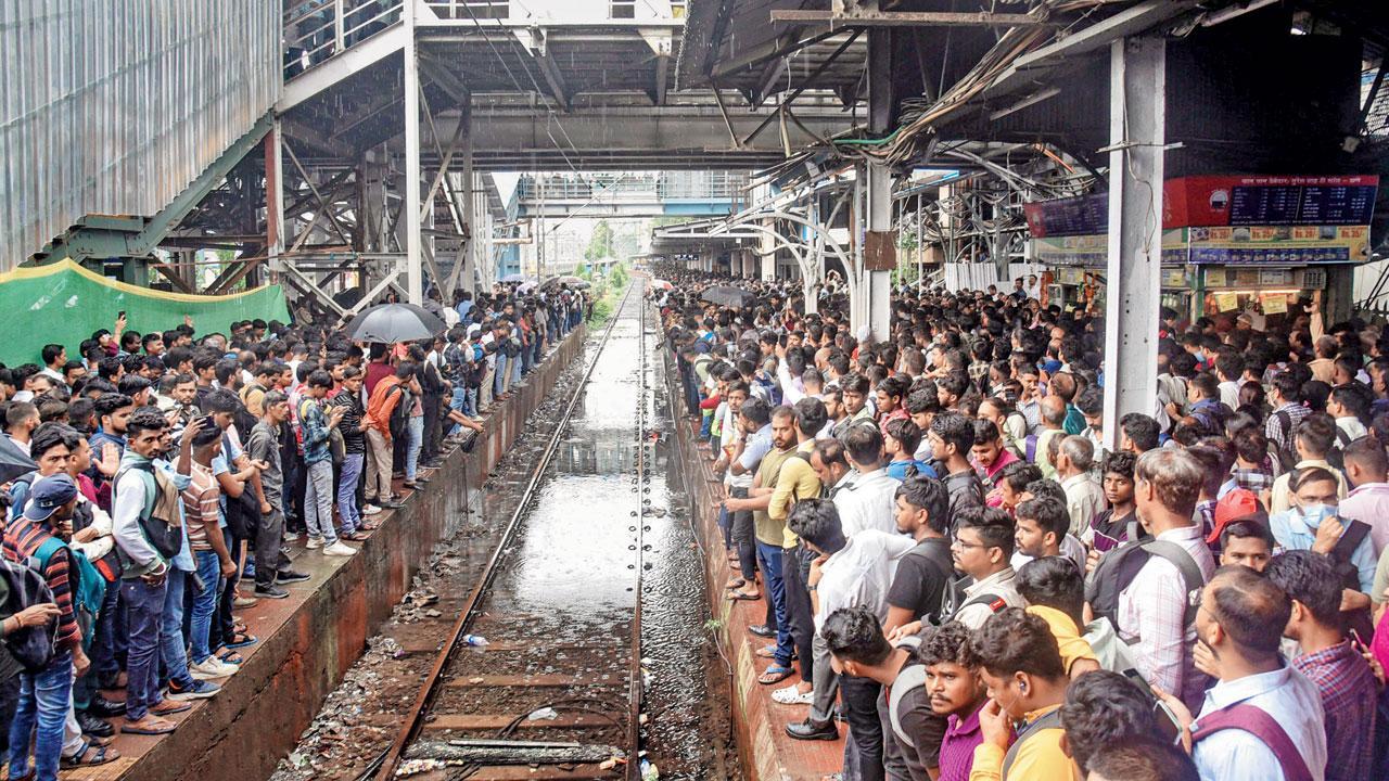 થાણેમાં ટ્રેનની રાહ જોતા મુસાફરો
