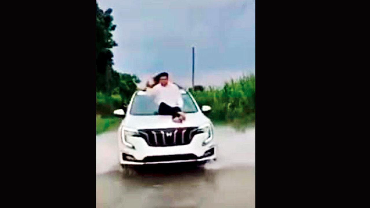 પૂરમાં ભરાયેલા પાણીમાંથી પસાર થઈ રહેલી કારના બોનેટ પર બેસેલા કૉન્ગ્રેસના સંસદસભ્ય ડૉ. પ્રશાંત પડોળે.