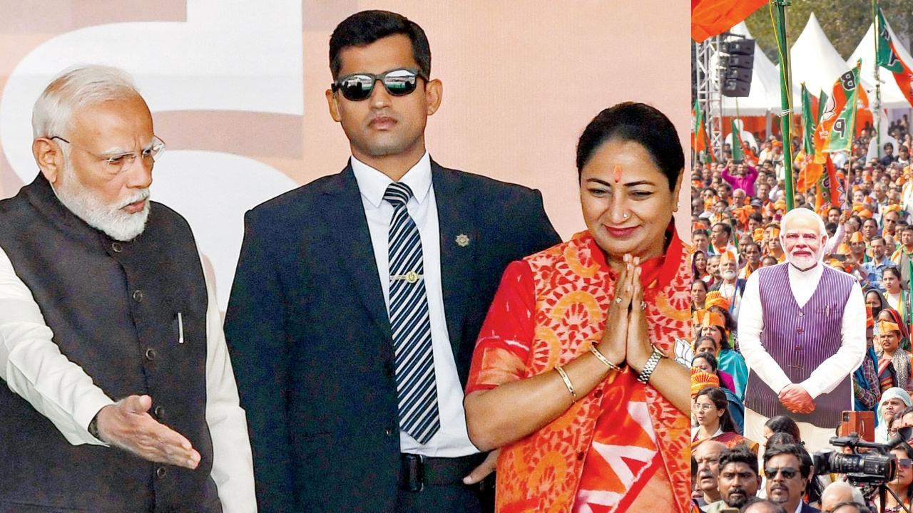 ગઈ કાલે રામલીલા મેદાનમાં આયોજિત સમારોહમાં રેખા ગુપ્તાને શપથ લેવા આગળ આવવાનો ઇશારો કરતા નરેન્દ્ર મોદી. આ સમારોહમાં BJPના કાર્યકરો વડા પ્રધાનનું ફુલ સાઇઝ કટઆઉટ લઈને આવ્યા હતા.