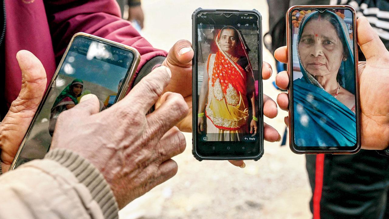 પ્રયાગરાજમાં ગઈ કાલે શબઘરની બહાર પોતાના સ્વજનની ઓળખ માટે તેમના ફોટો સાથે રાહ જોતા લોકો.