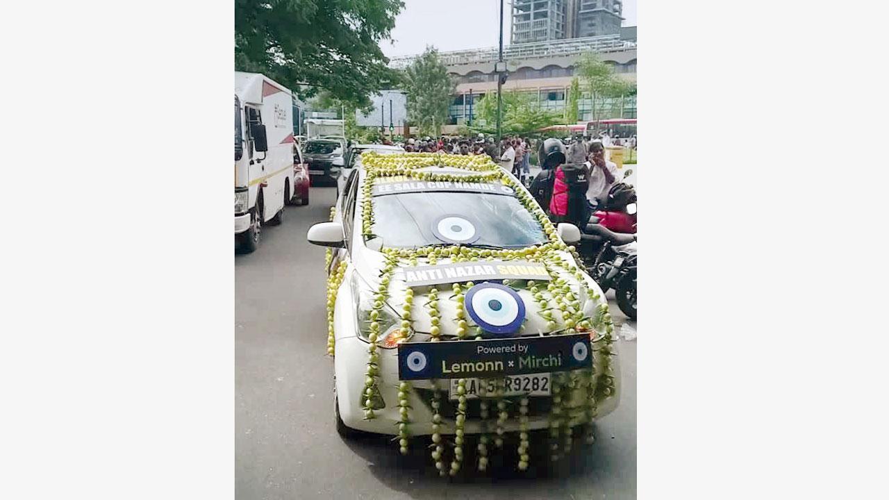 સિલ્વર કલરની કારને લીંબુ-મરચાંની લડીઓથી સજાવી