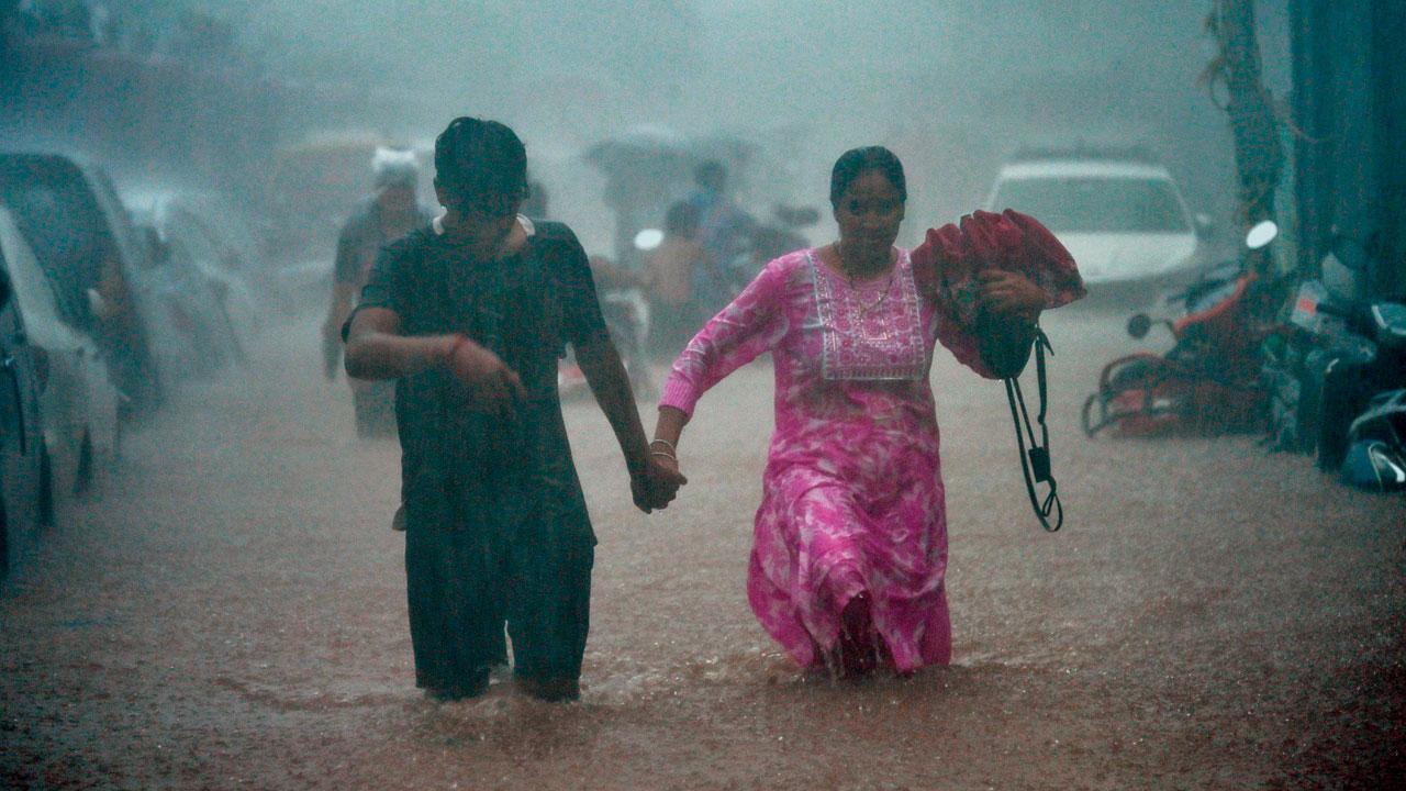  મલબાર હિલમાં જળબંબાકાર રસ્તા પર ચાલતું યુગલ.