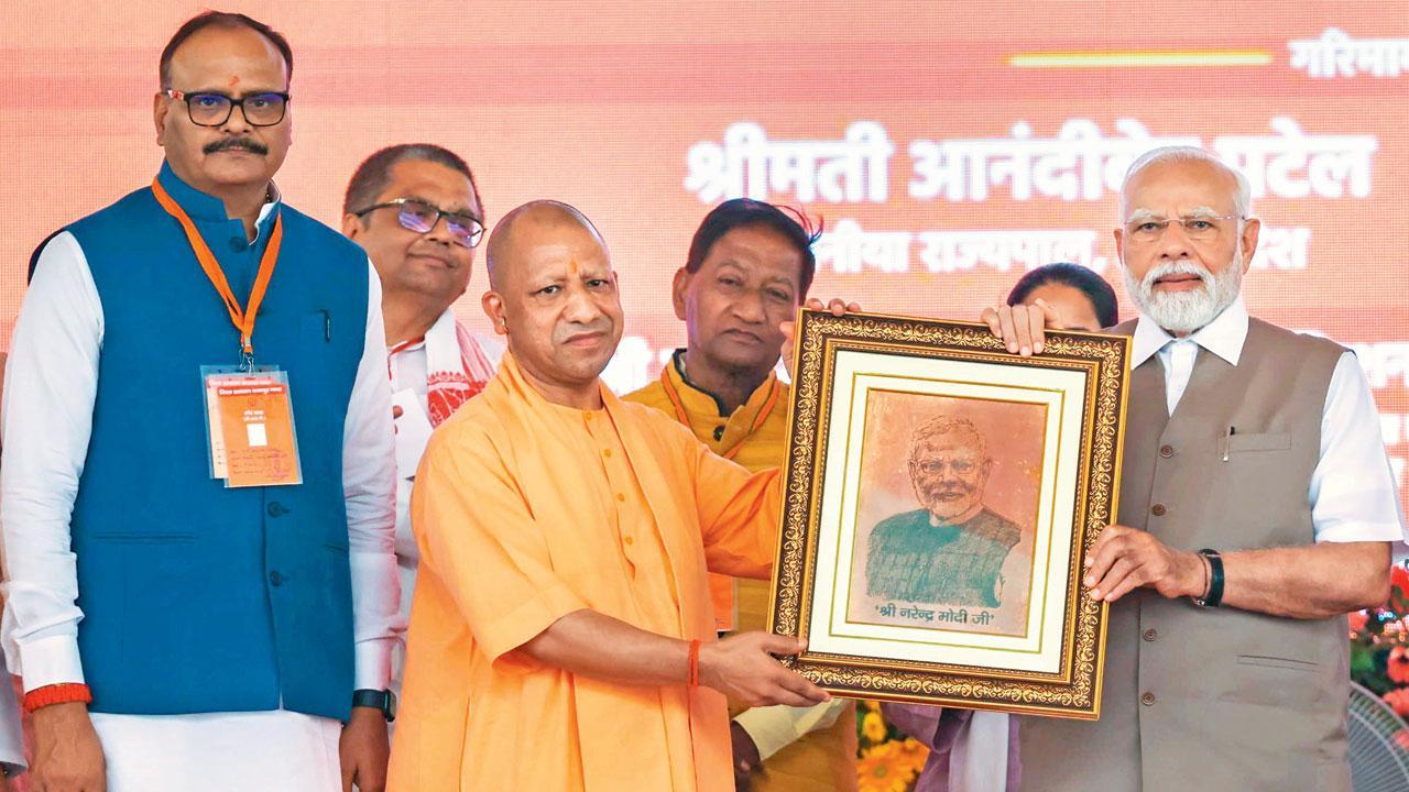 ગઈ કાલે કાનપુરમાં નરેન્દ્ર મોદીને તેમના ચિત્રવાળી ફોટોફ્રેમ ભેટ આપતા ઉત્તર પ્રદેશના મુખ્ય પ્રધાન યોગી આદિત્યનાથ.