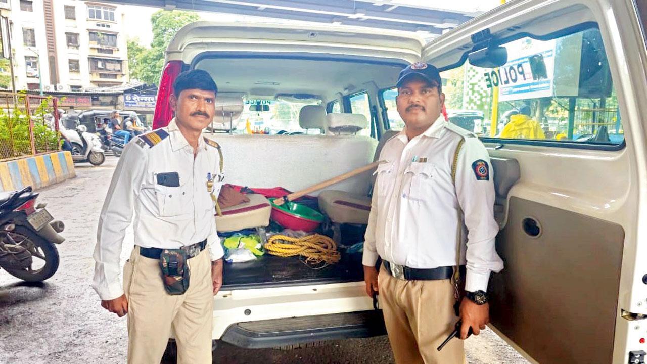 ટ્રૅફિક વાહનમાં ટ્રૅફિક અધિકારીઓ ખાડા ભરવાની વસ્તુઓ સાથે.