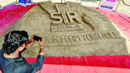 SIR વિશે કેરલાના કોઝિકોડમાં બનાવવામાં આવેલા રેતશિલ્પનો ફોટો પાડતી એક વ્યક્તિ.