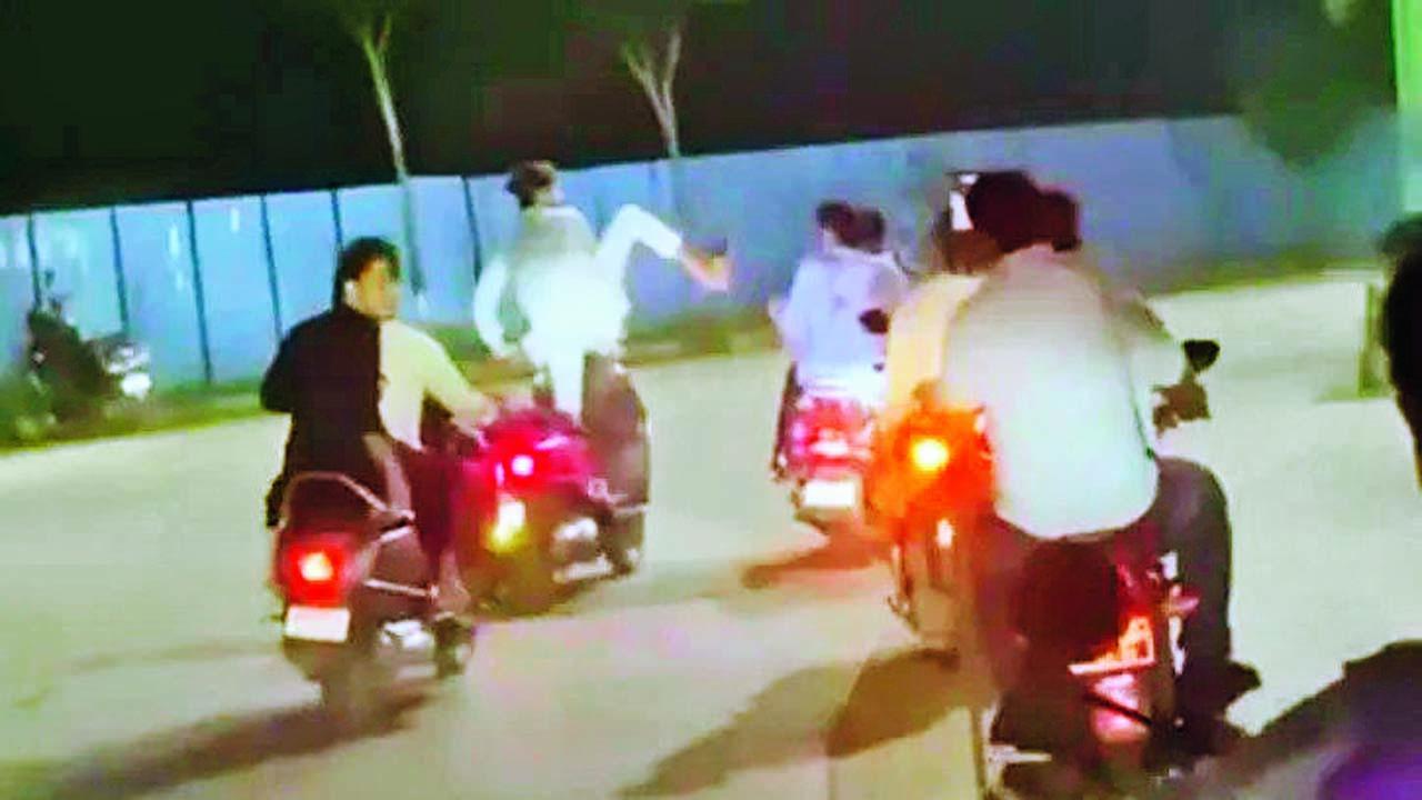 એક પગ પર ઊભા રહીને ટુ-વ્હીલર ચલાવતાં-ચલાવતાં બીજા બાઇકરને લાત મારતો યુવક.