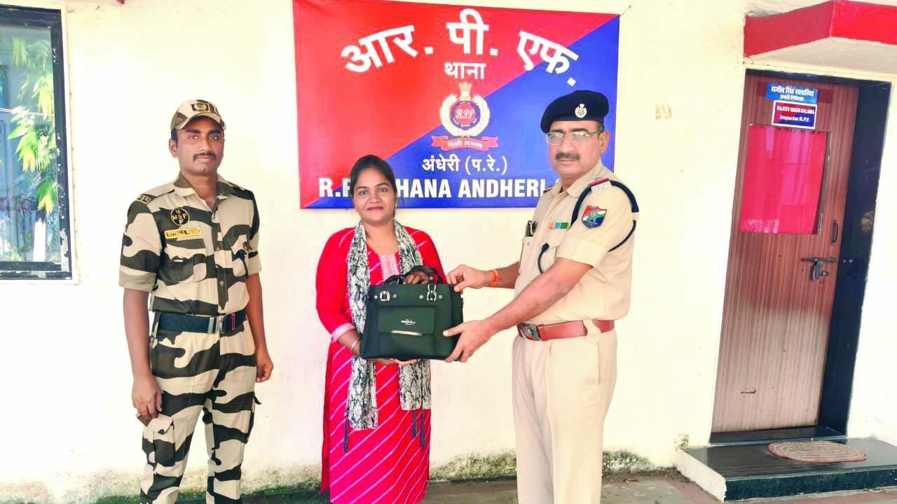 પૂજા કોળીને તેની બૅગ પાછી આપી રહેલા RPFના અધિકારી.