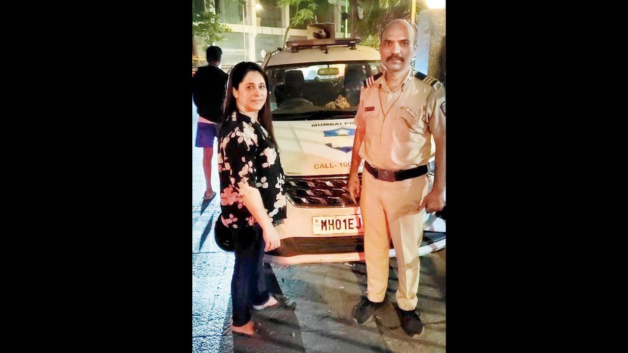 નિકી રૂપારેલ સાથે પોલીસ-અધિકારીઓ પોલીસની વૅન બાજુમાં દેખાય છે