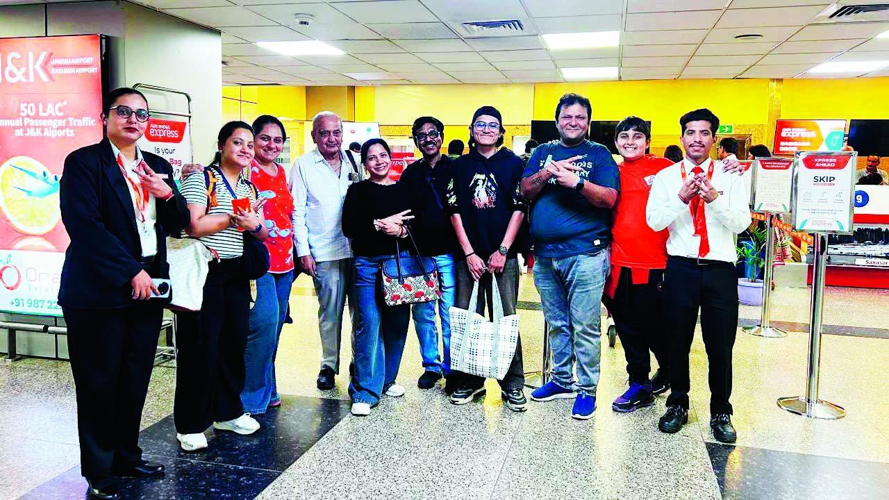 જમ્મુ ઍરપોર્ટ પર ઍરલાઇનના સ્ટાફ સાથે ઊભેલા મુંબઈના બે ગુજરાતી પરિવારો.