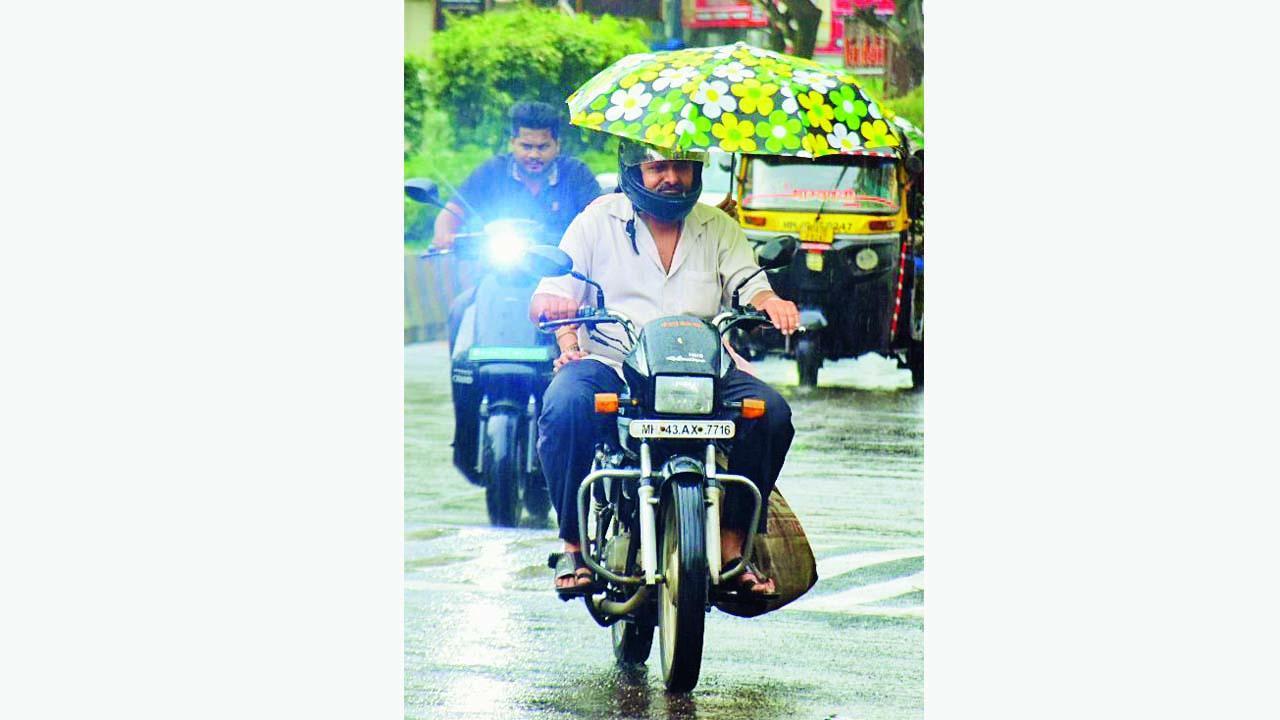ગઈ કાલે નવી મુંબઈમાં વરસાદમાં બાઇકરને છત્રીનું કવચ આપતી પાછળ બેઠેલી વ્યક્તિ.