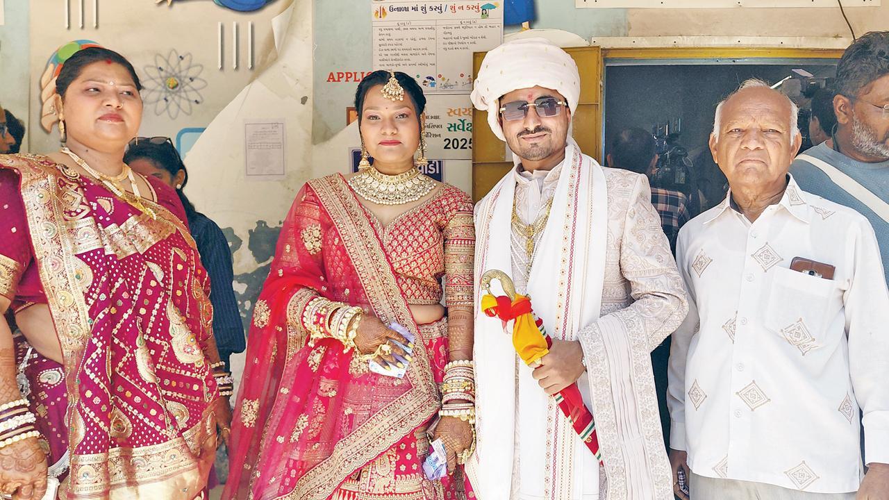 મતદાન મથકની બહાર પરિવાર સાથે કન્યા સુઝાન સોલંકી અને વરરાજા નીલેશ જાદવ