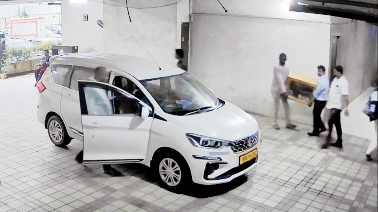 સોસાયટીમાંથી અજગરને લઈ જતા વનવિભાગના અધિકારીઓ.
