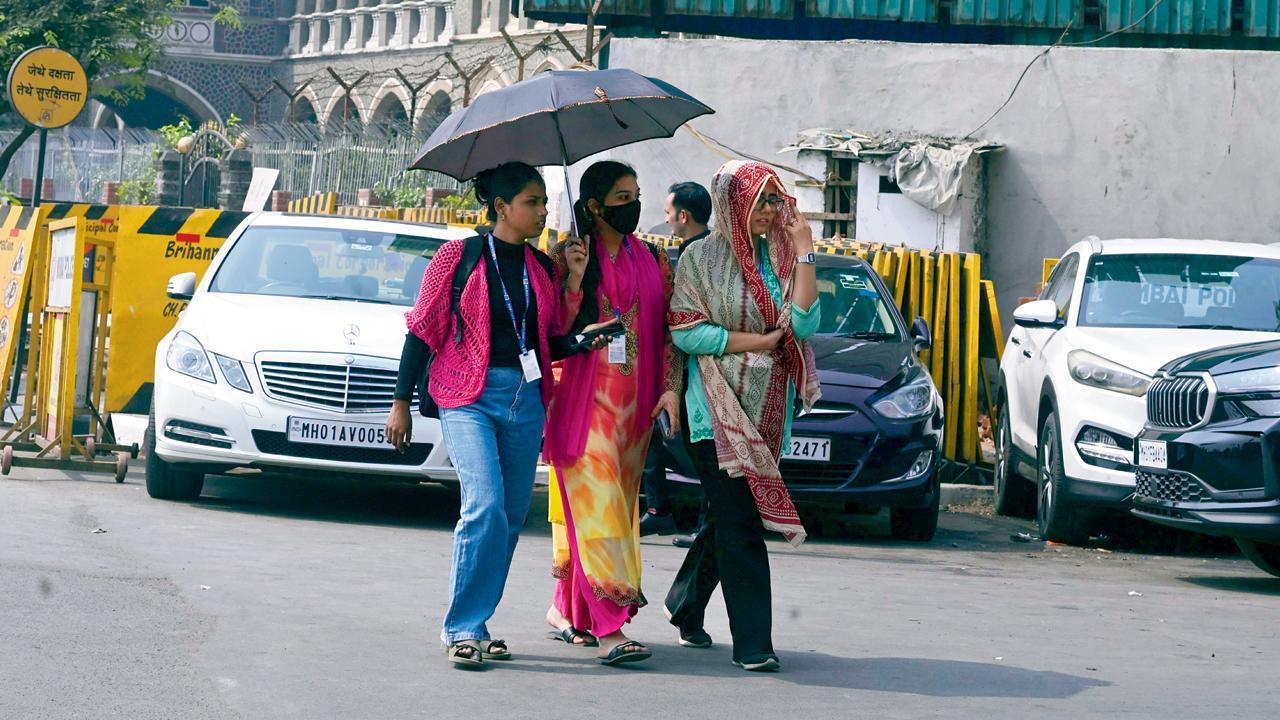 ગઈ કાલે ગિરગામ ચોપાટી પર ગરમીથી બચવા છત્રીનો ઉપયોગ કરવો પડ્યો હતો આ યુવતીઓએ (તસવીર: આશિષ રાજે)