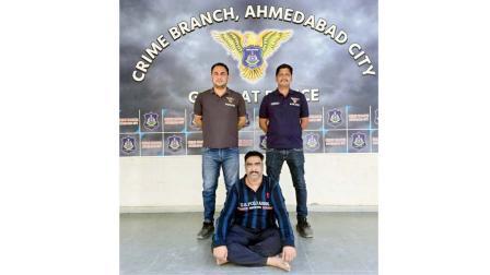 અમદાવાદ ક્રાઇમ બ્રાન્ચે ઝડપેલો આરોપી સુજિત જાદવ નીચે બેઠો છે.