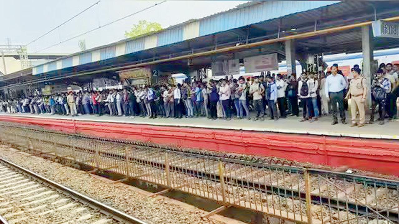 નાલાસોપારામાં પોલીસની હાજરીમાં પ્રવાસીઓ ટ્રેનમાં જવા માટે લાઇન લગાવીને ઊભા રહે છે.