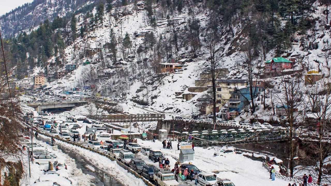 મનાલીમાં વાહનો અટવાઈ પડ્યાં હોવાથી પગપાળા જતા ટૂરિસ્ટો.