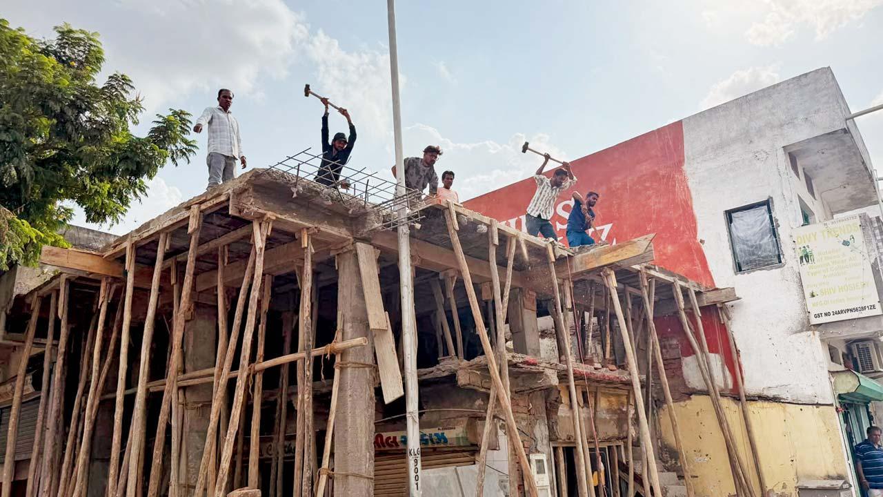 પછી : ગેરકાયદે બાંધકામ હટાવીને સ્ટ્રીટલાઇટના પોલને ખુલ્લો કરવાની કાર્યવાહી કરતા મજૂરો.