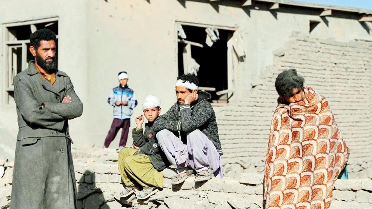 ગુરુવારની રાતે પાકિસ્તાને કરેલા હુમલામાં કાબુલનાં ક્ષતિગ્રસ્ત ઘરોની બહાર બેઠેલા લોકો