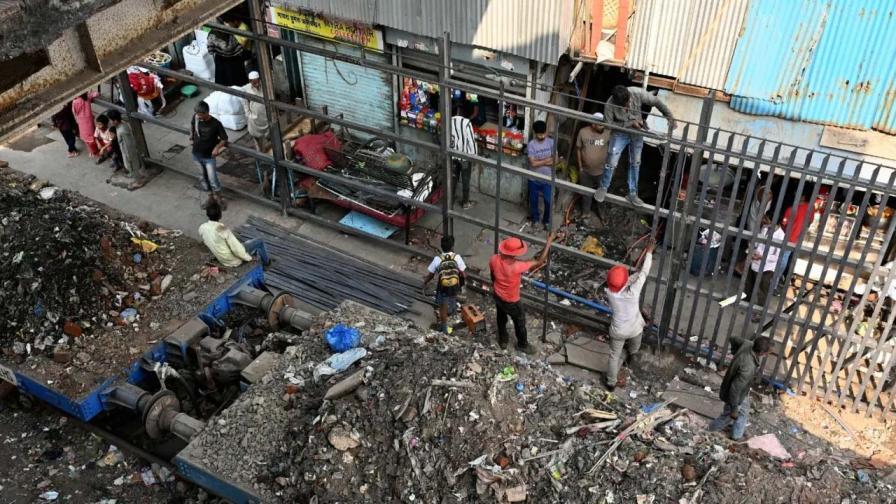 પશ્ચિમ રેલવેના કોન્ટ્રાક્ટ કામદારો દ્વારા મંગળવારે સવારે બાંદ્રા પૂર્વમાં ગરીબ નગર નજીક રેલવે ટ્રેક પર રેલિંગ લગાવવાની અને કચરો સાફ કરવાની કામગીરી હાથ ધરાઇ હતી. (તસવીર- સતેજ શિંદે)