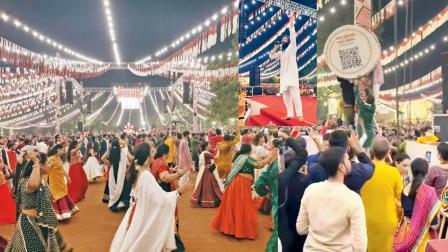 નવશક્તિમાં સ્ટેજની ફરતે ગરબે ઘૂમતા ખેલૈયાઓ, સ્ટેજ પરથી લોકગાયક હાર્દિક દવેએ ડોનેશન ન આપવા માટે અપીલ કરી હતી,  QR કોડ હટાવી રહેલા નવશક્તિ નવરાત્રિની ટીમના સભ્યો. 