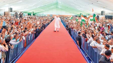 સભામંડપમાં બનાવેલા રૅમ્પ પરથી ચાલતાં-ચાલતાં આગળ વધી રહેલા નરેન્દ્ર મોદી.